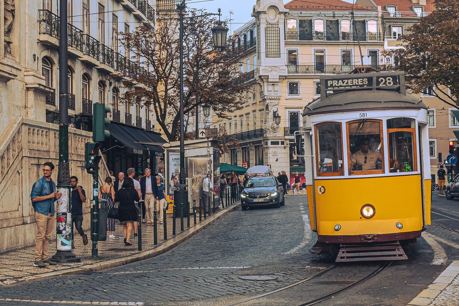 A yellow tram on a cobbled street in Lisbon